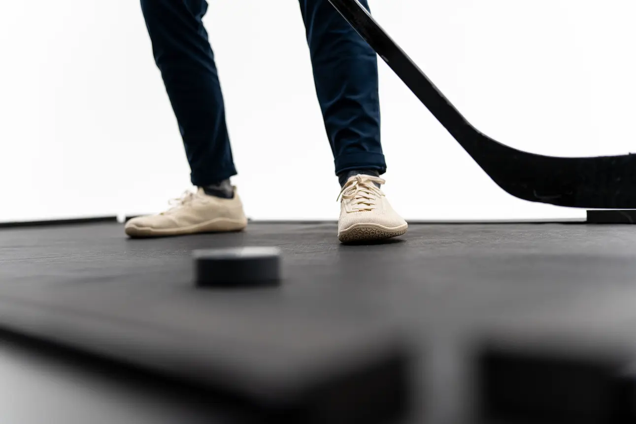 Feet, stick, and puck on the Danglemat surface.